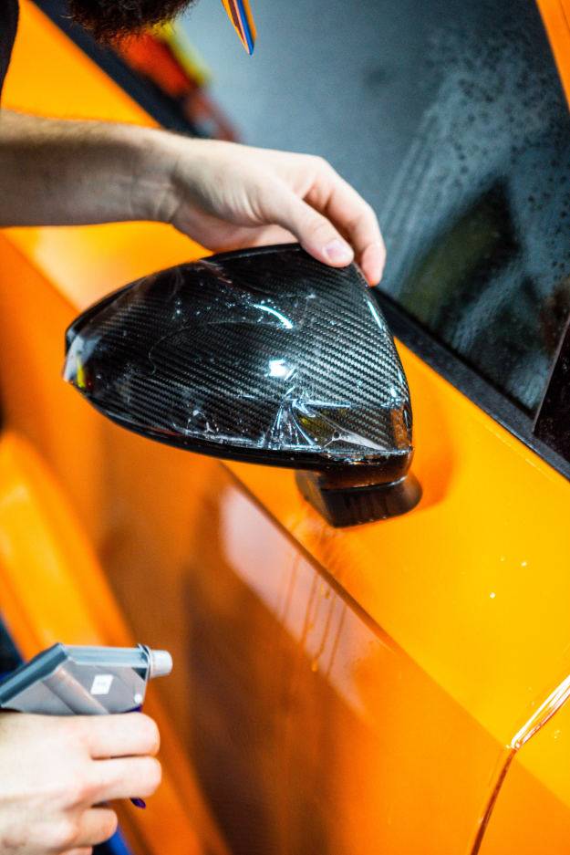 paint protection film being applied to tesla rear view window